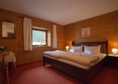Doppelzimmer mit Holzverkleidung in der Pension