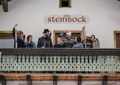Skifahrer auf dem Balkon der Pension